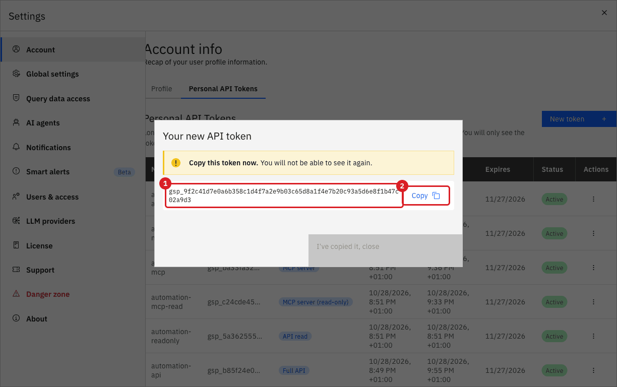 The Your new API token dialog with the token value marked by annotation 1 and the Copy button marked by annotation 2